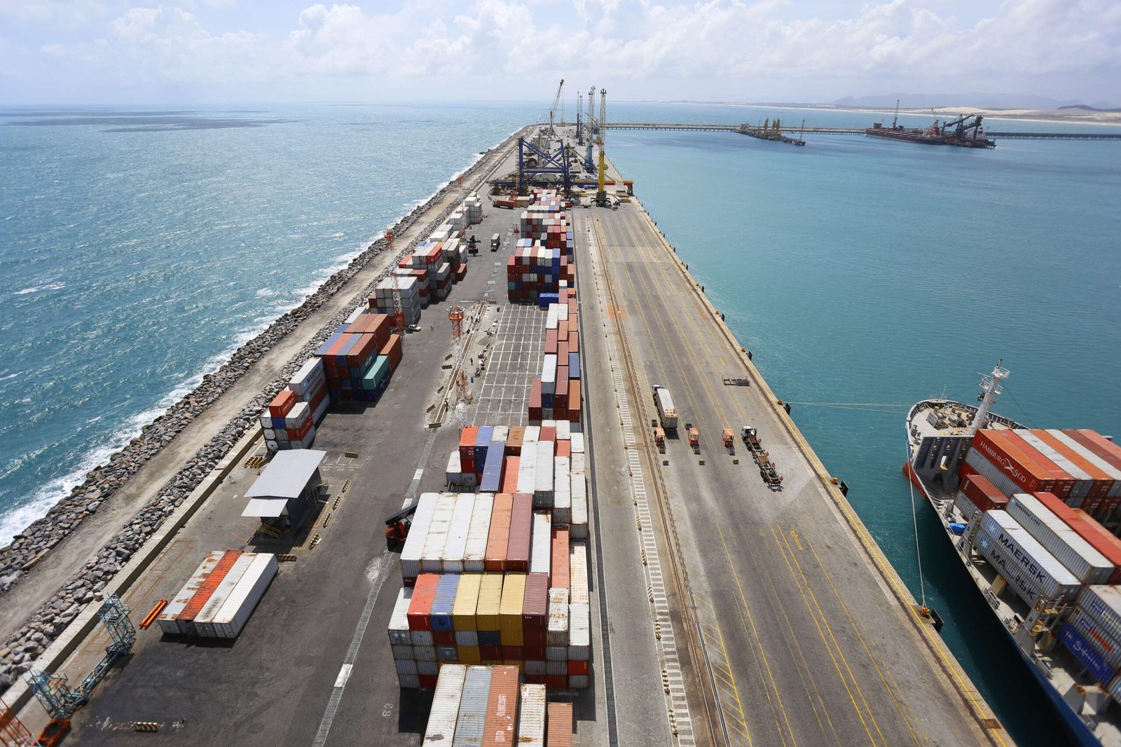 Terminal portuário com navio atracado e containers